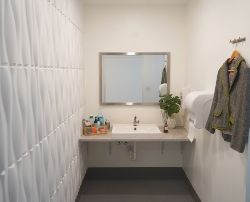 REV Studio Bathroom Clean modern bathroom with clothing hooks and basket of amenities on counter