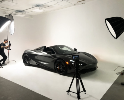 Photoshoot of a Sports Car Black sports car on white cyc wall with lighting
