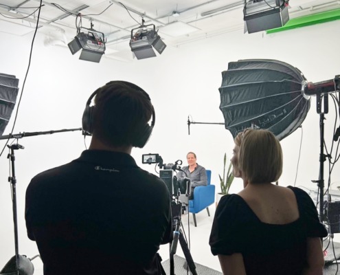 REV Studio Production Crew in Action Production Crew overseeing video content production with client on set in chair