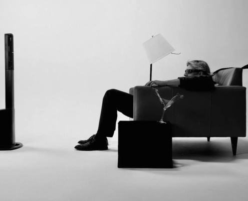 Black and white photo of a subject reclining in a leather chair, pushed back by an unseen force, mimicking the classic Maxell ad.